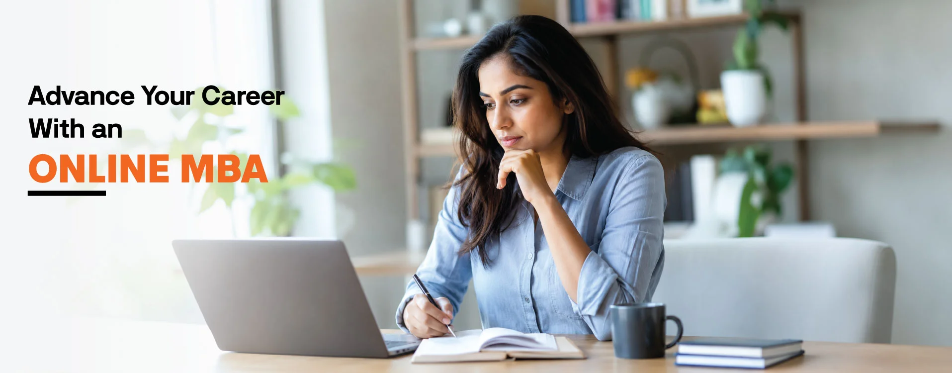 Working professional sitting at a desk with a laptop in a bright office space.